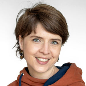 Foto von Carmen Mauerer. Sie lacht freundlich und hat kurze braune Haare und helle Haut.