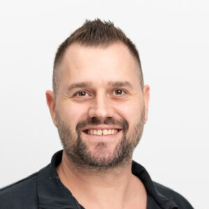 Foto von Martin Streit. Er lacht freundlich, hat helle Haut und dunkle kurze Haare und einen kurzen Bart.
