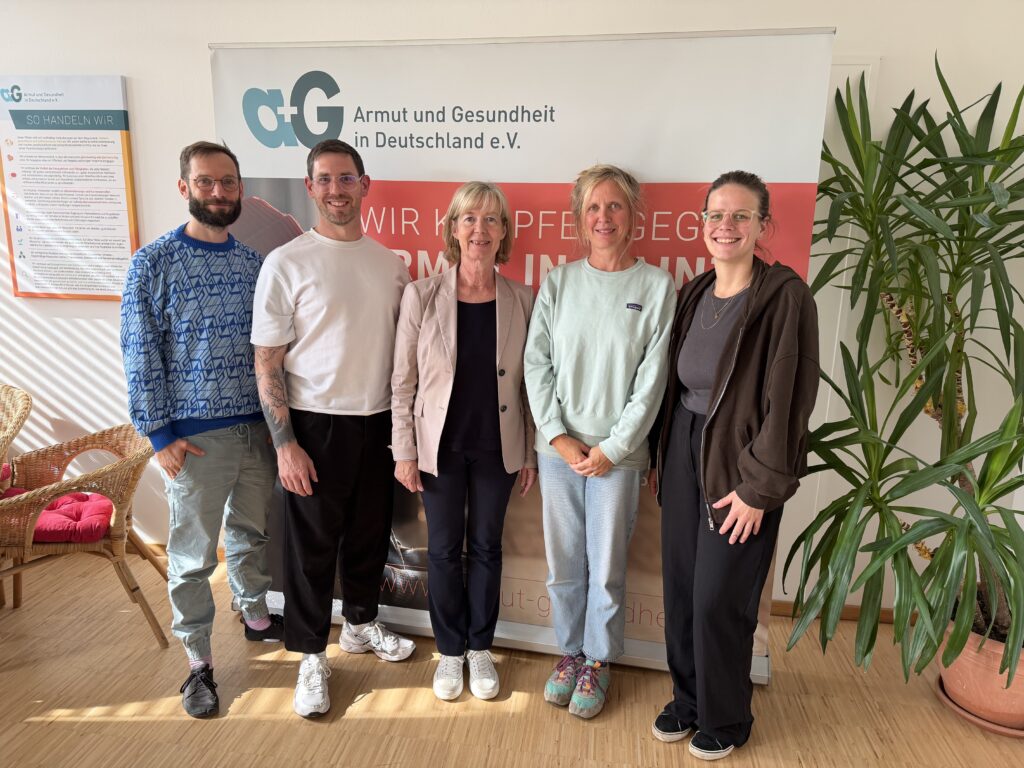 Vor einem Banner von a+G stehen 5 Menschen: Jari Trabert, Sebastian Maaßen, Nele Wilk und Katharina Holl von a+G und in der Mitte Finanzministerin Doris Ahnen.